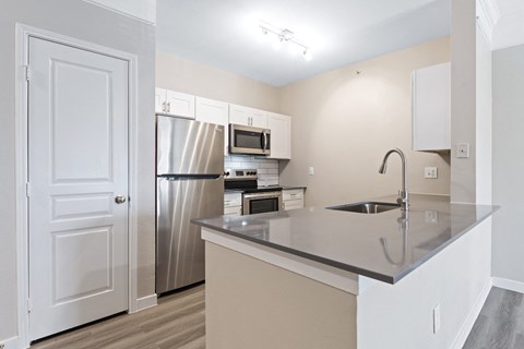 a kitchen with a large island and stainless steel appliances